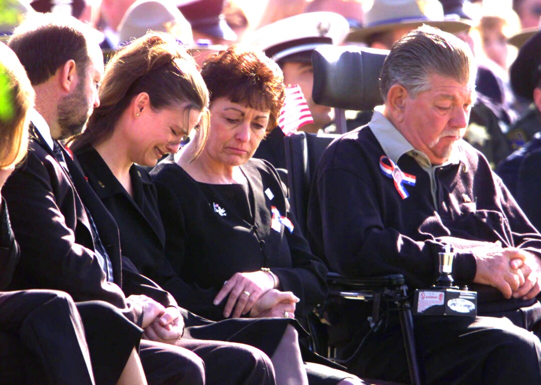 Shawna, left, is flanked by her parents, Russ and Penny Campbell, during the service for Cody.