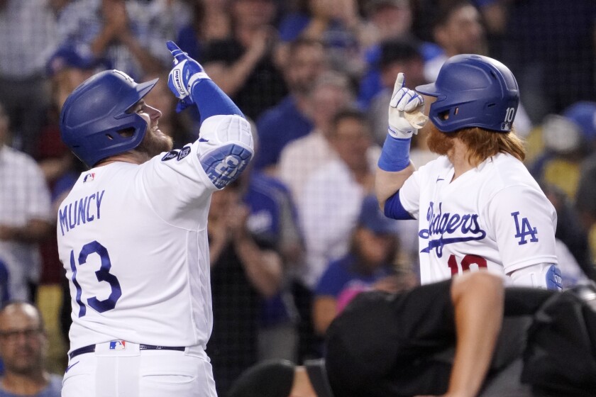 Los Angeles Dodgers' Max Muncy, left, is congratulated by Justin Turner after hitting a solo home run during the third inning of a baseball game against the San Francisco Giants Tuesday, June 29, 2021, in Los Angeles. (AP Photo/Mark J. Terrill)