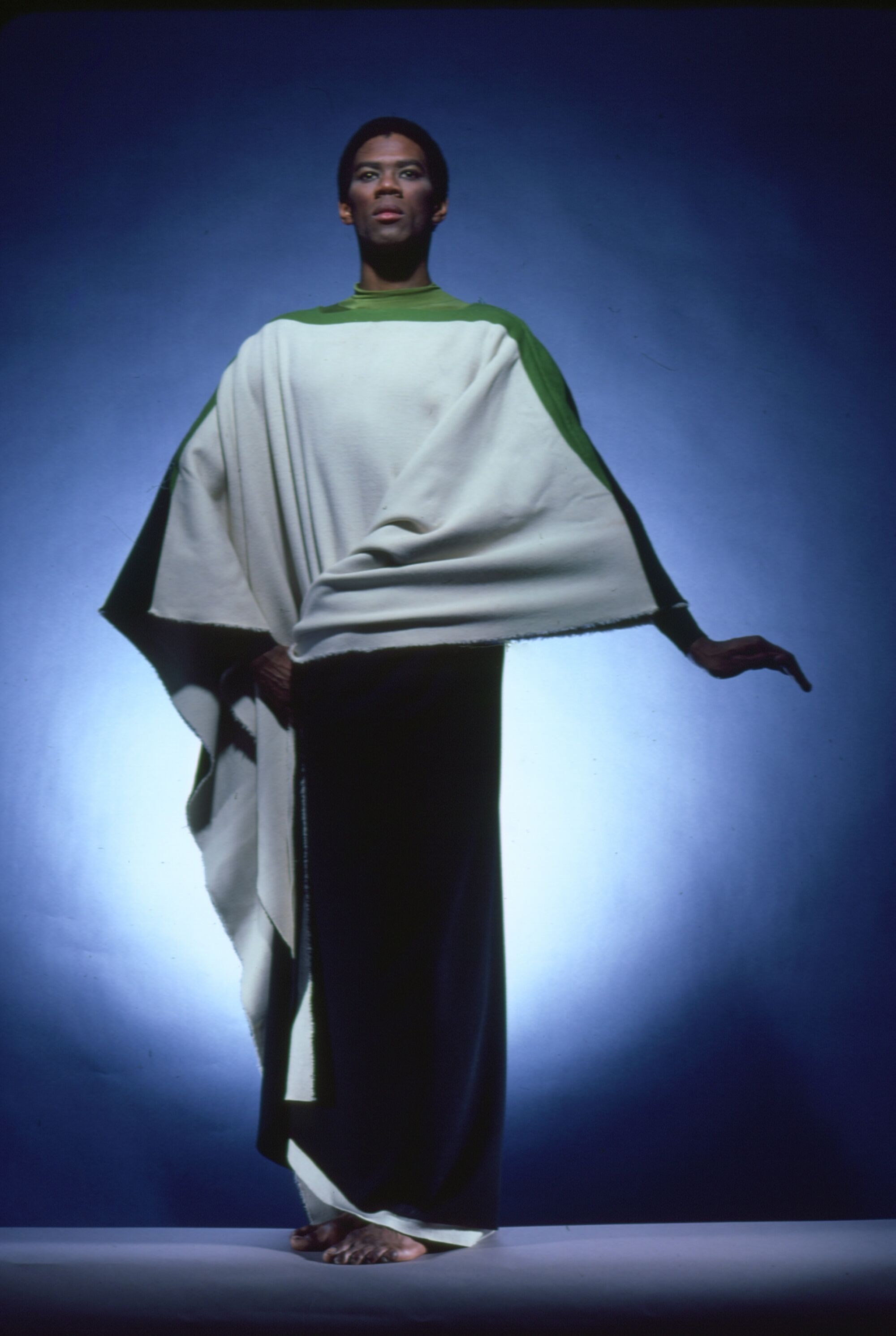 A dancer wearing a draped white and green costume.