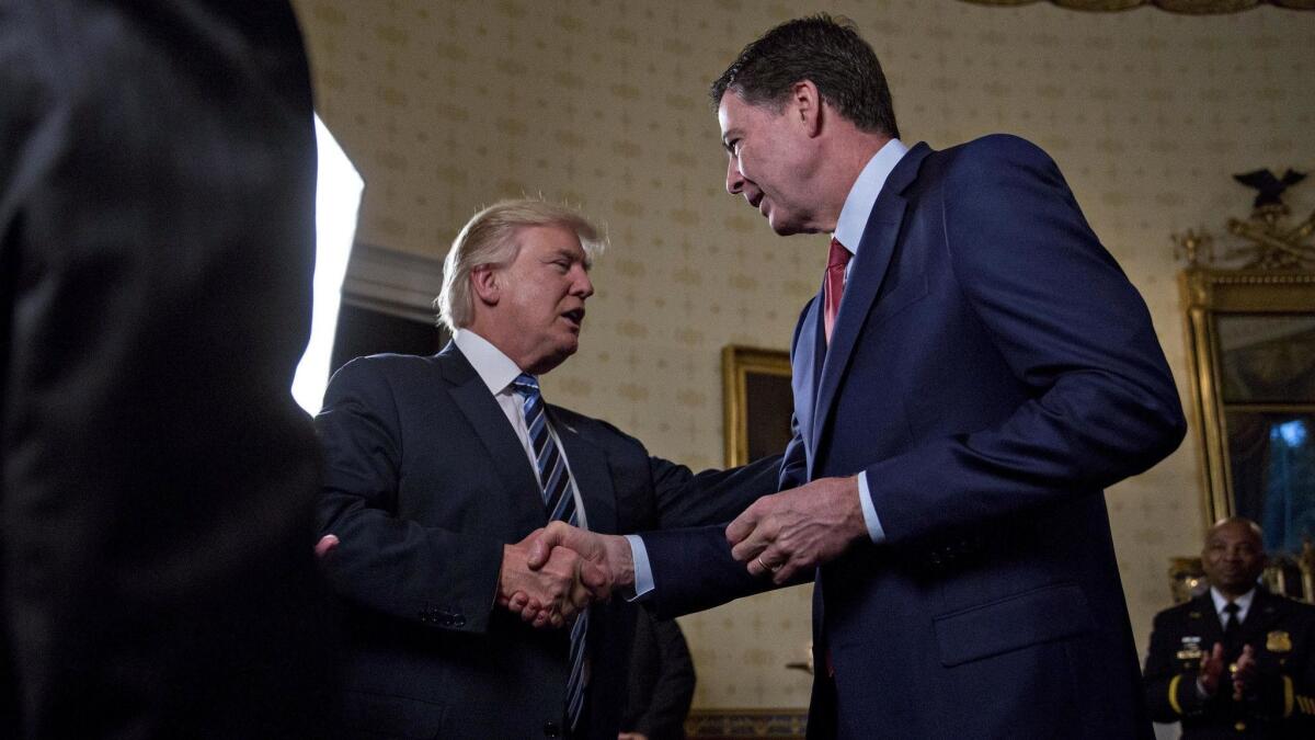 President Trump shakes hands with then-FBI Director James Comey at the White House on Jan. 22, 2017. Trump fired Comey on May 9.