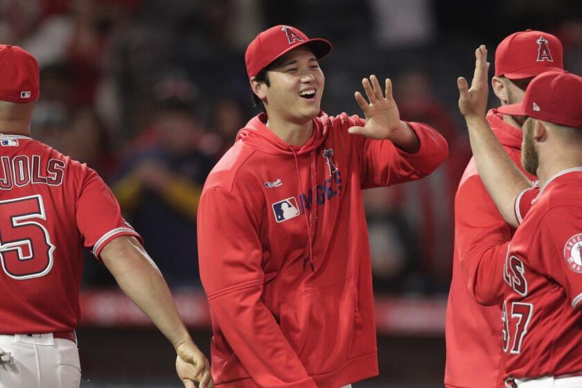 Los Angeles Angels' Shohei Ohtani, center, of Japan, celebrates the team's 3-1 over the Texas Rangers in a baseball gamewith relief pitcher Cody Allen on Friday, April 5, 2019, in Anaheim, Calif. (AP Photo/Jae C. Hong)