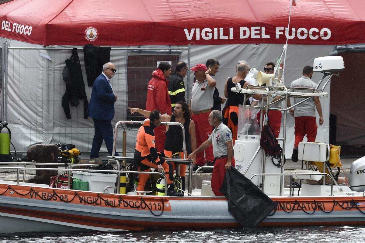 Bomberos y buzos italianos atracan en el puerto de Porticello, en el sur de Italia,