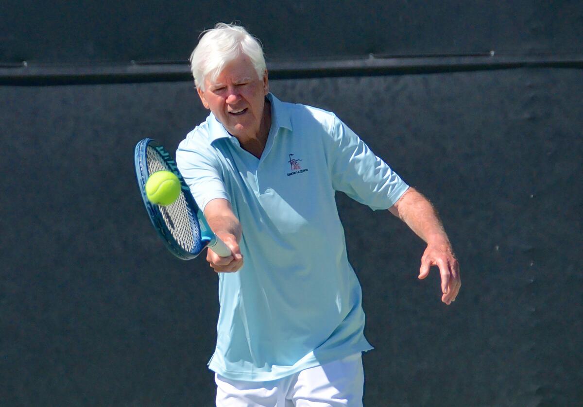 Larry Collins hits a forehand as he plays tennis at the Palisades Tennis Club in Newport Beach on Monday.