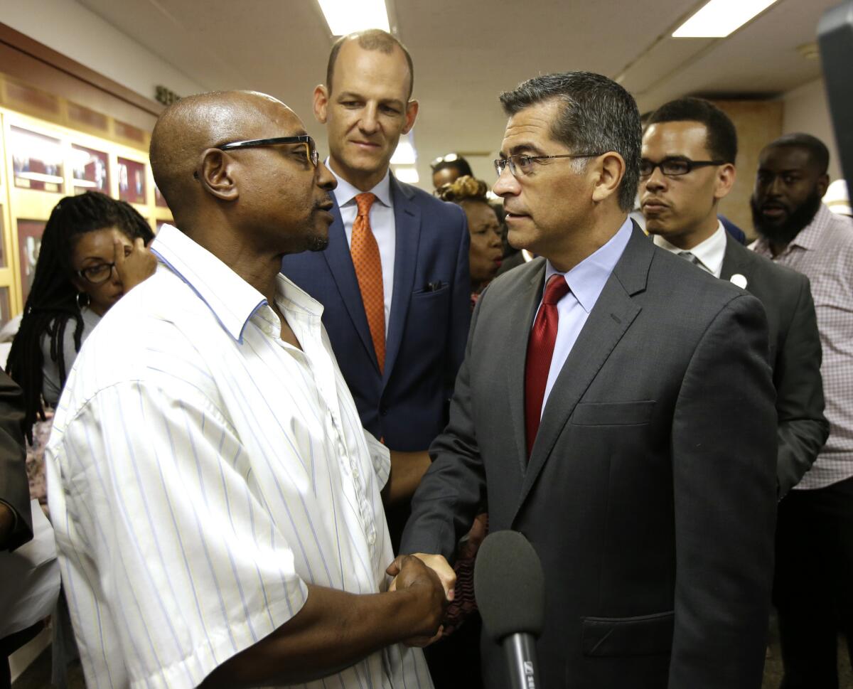 Earlier this month, California Atty. Gen. Xavier Becerra, right, shakes a man's hand after a legislative committee hearing on police shootings.