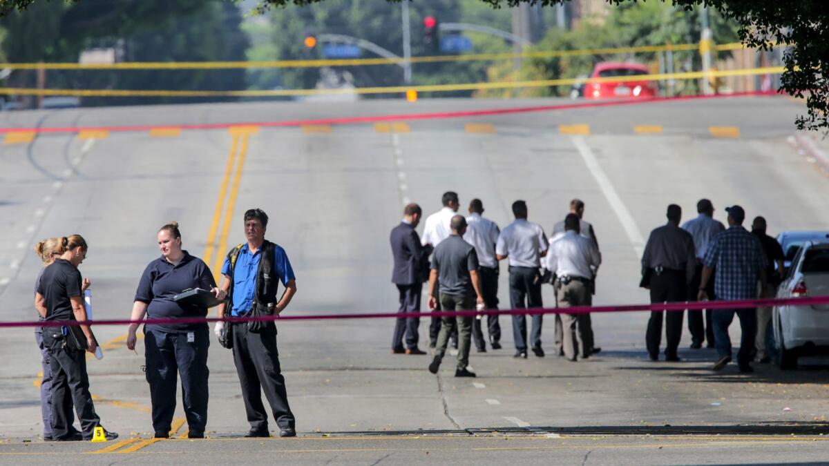 Investigators at the intersection of Wilshire Boulevard and Union Avenue. where a man was shot by Los Angeles Unified School District police Saturday morning,