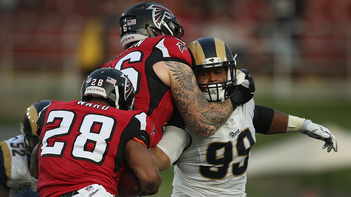 Rams defensive tackle Aaron Donald (99), trying to reach around Atlanta's Tom Compton to reach running back Terron Ward, is going to his third Pro Bowl.