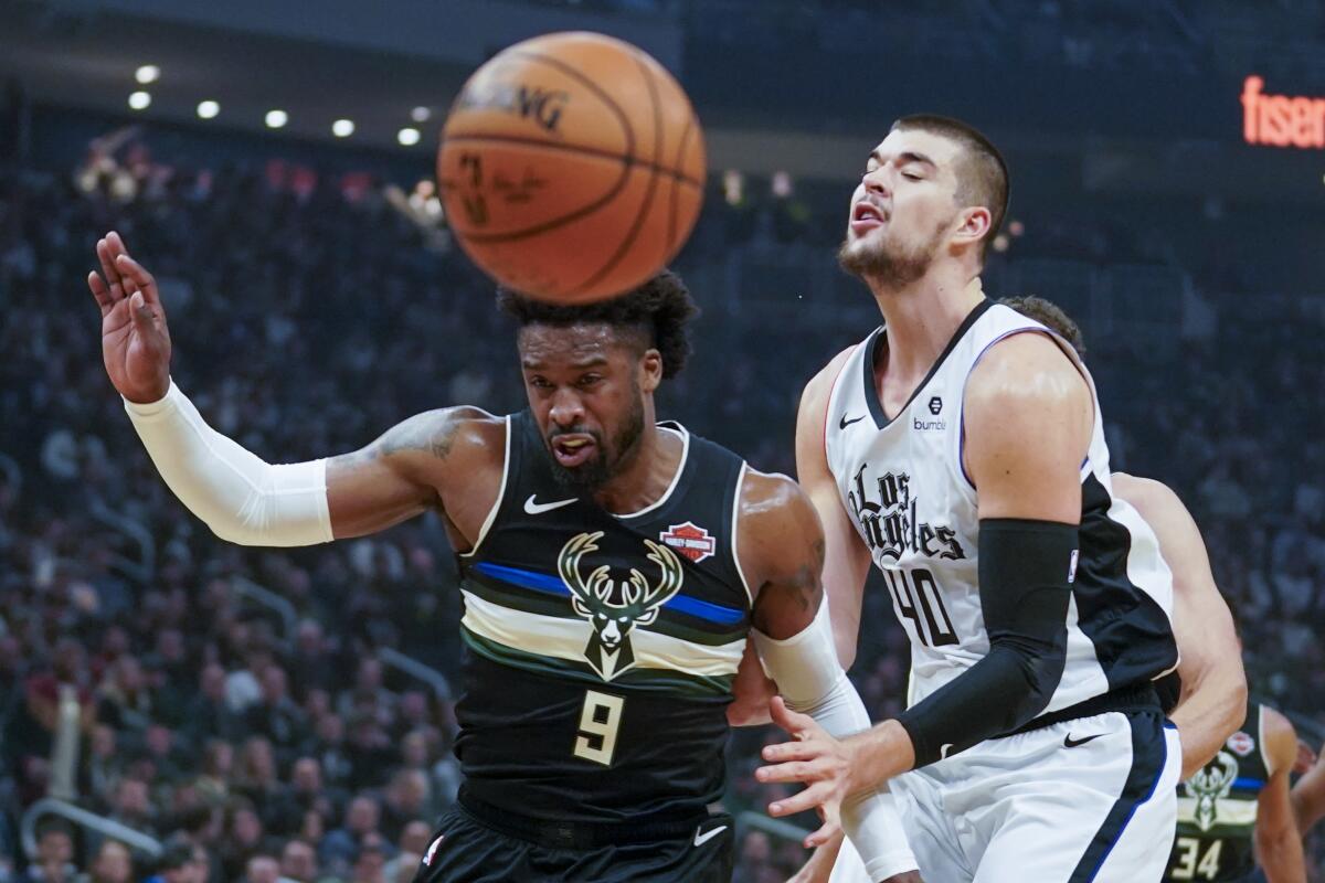 Milwaukee Bucks' Wesley Matthews and Los Angeles Clippers' JaMychal Green battle for a loose ball during the first half of an NBA basketball game Friday, Dec. 6, 2019, in Milwaukee. (AP Photo/Morry Gash)