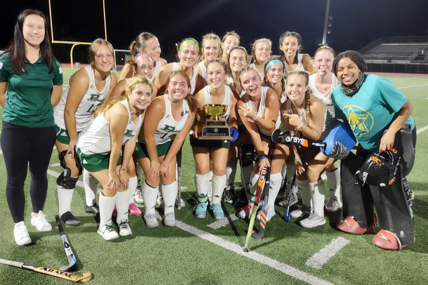 Girls varsity field hockey players on the Poway High School team celebrate their victory and Kiwanis Cup award.