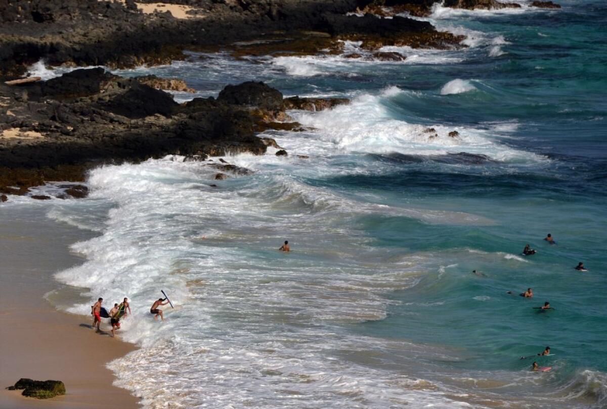 People enjoy a day at the beach in Hawaii in December; President Obama went snorkeling at Oahu's Hanauma Bay on his Christmas vacation, but, unlike King Canute, he did not command the tides to stop.