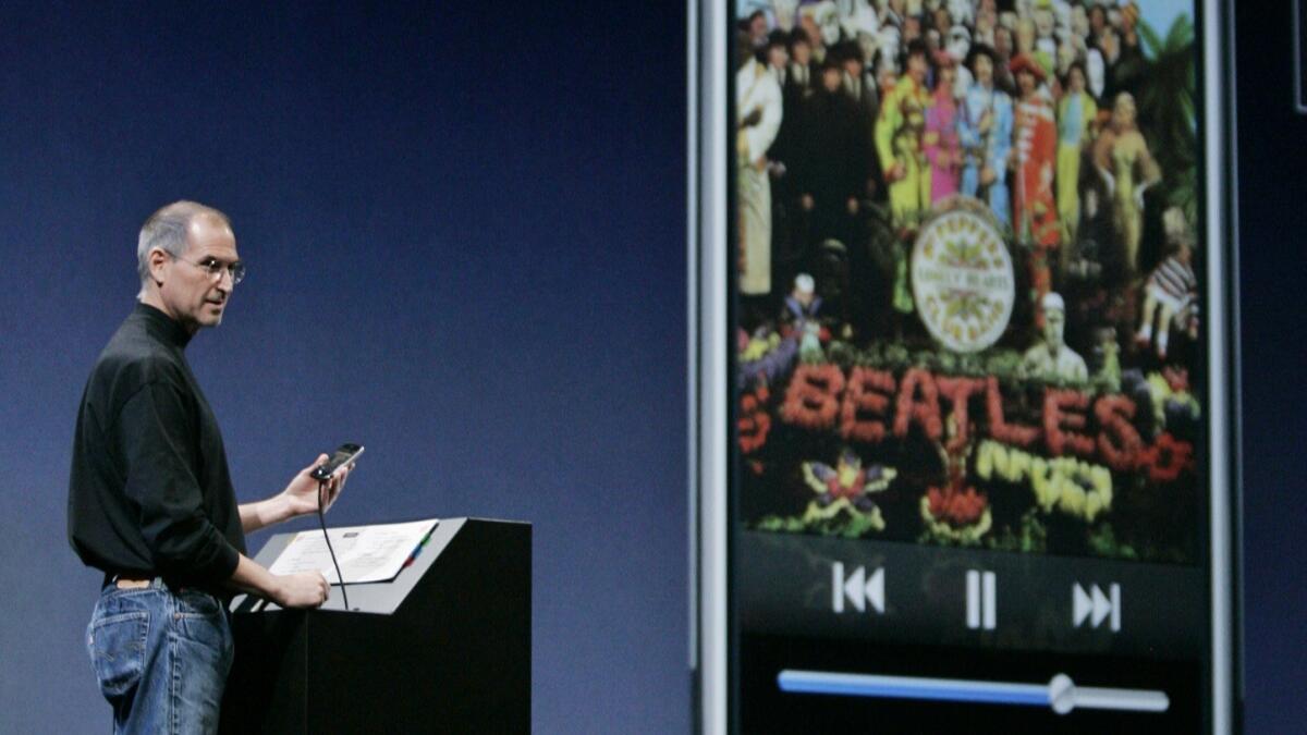 The late Apple Chief Executive Steve Jobs plays a Beatles song as he introduces the iPhone at the MacWorld Expo in San Francisco in 2007. Apple is expected to announce the discontinuation of its iTunes platform, according to reports.