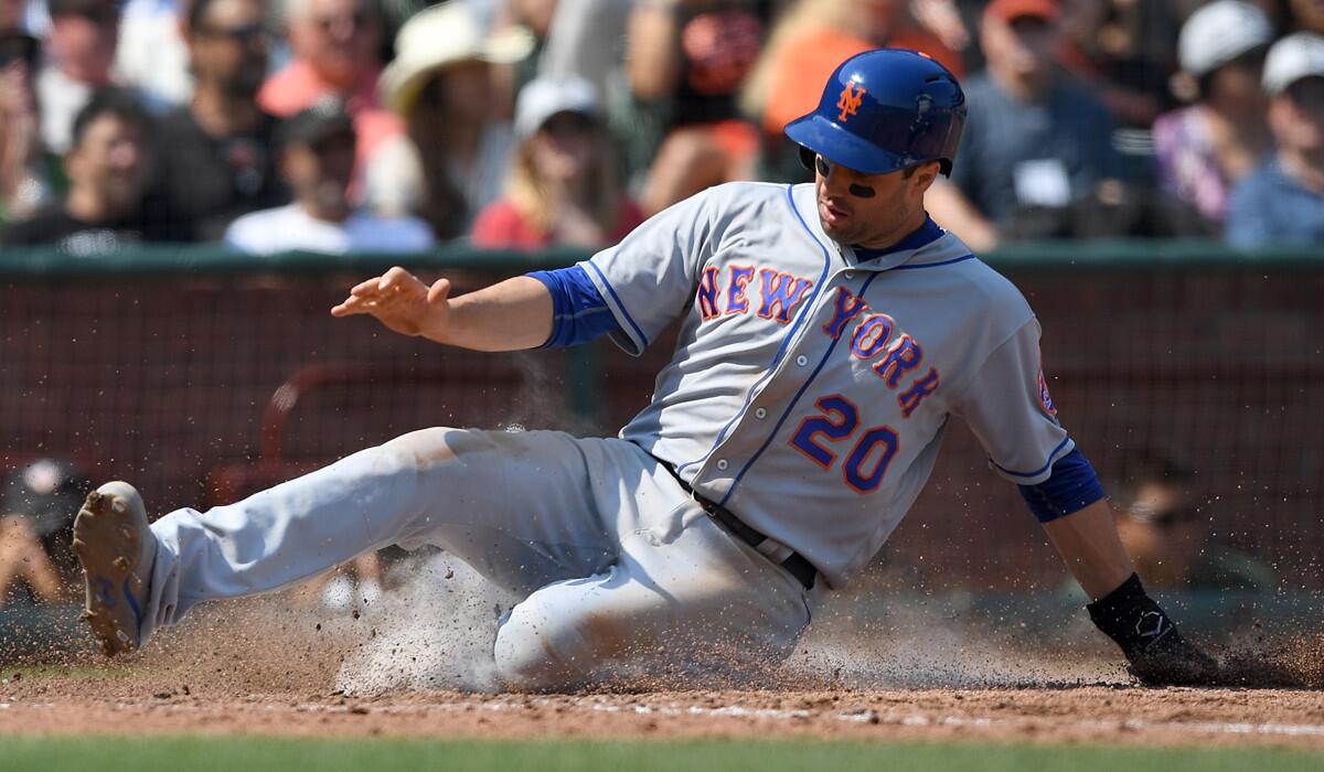 New York Mets second baseman Neil Walker slides at home scoring on an RBI single from Justin Ruggiano against the San Francisco Giants in the top of the six inning on Aug. 20.