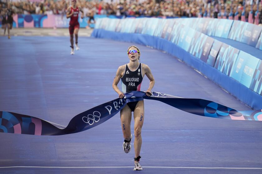 La francesa Cassandre Beaugrand cruza la meta al ganar el triatlón femenino de los Juegos Olímpicos de París, el miércoles 31 de julio de 2024. (AP Foto/Vadim Ghirda)