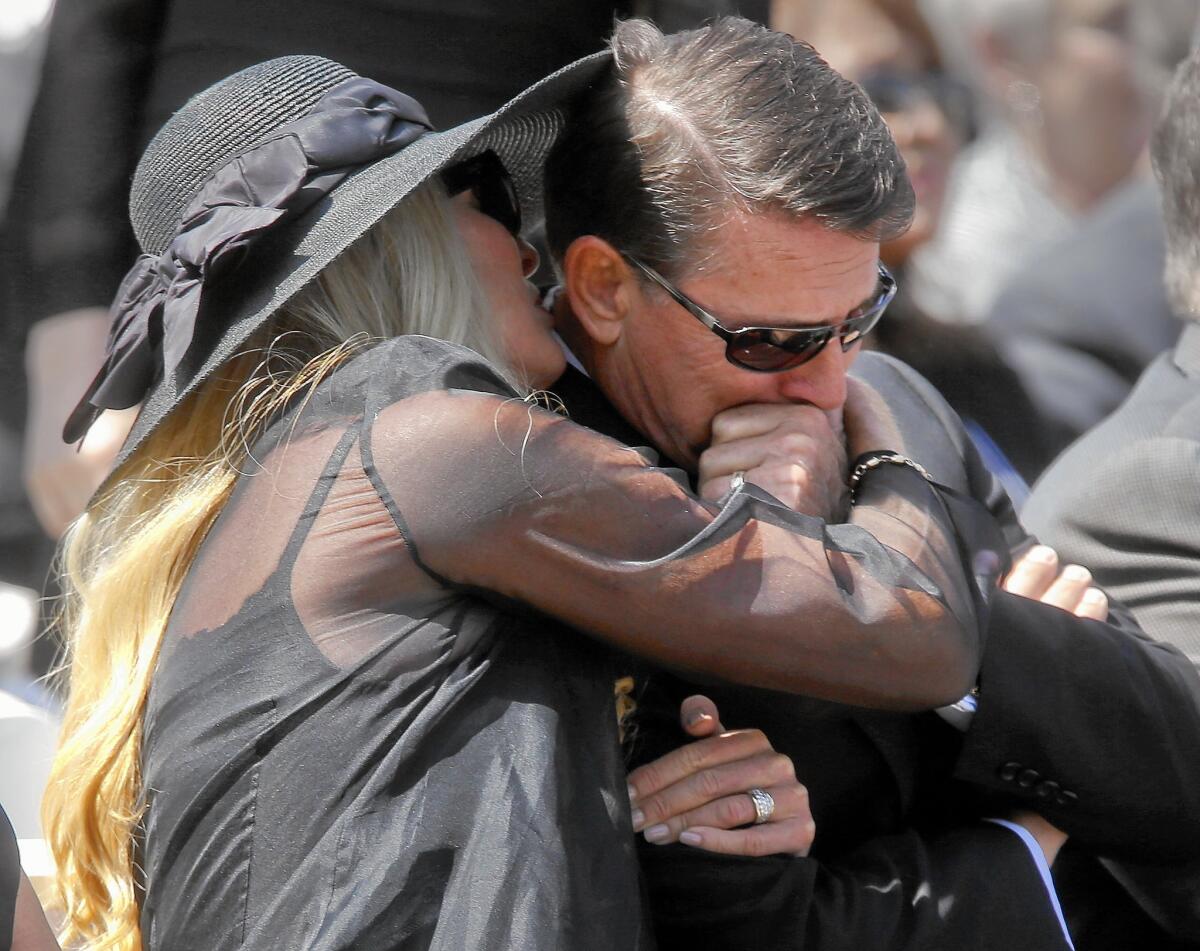 Robert A. Schuller is comforted by his wife, Donna, after delivering a tribute to his father, Robert H. Schuller.