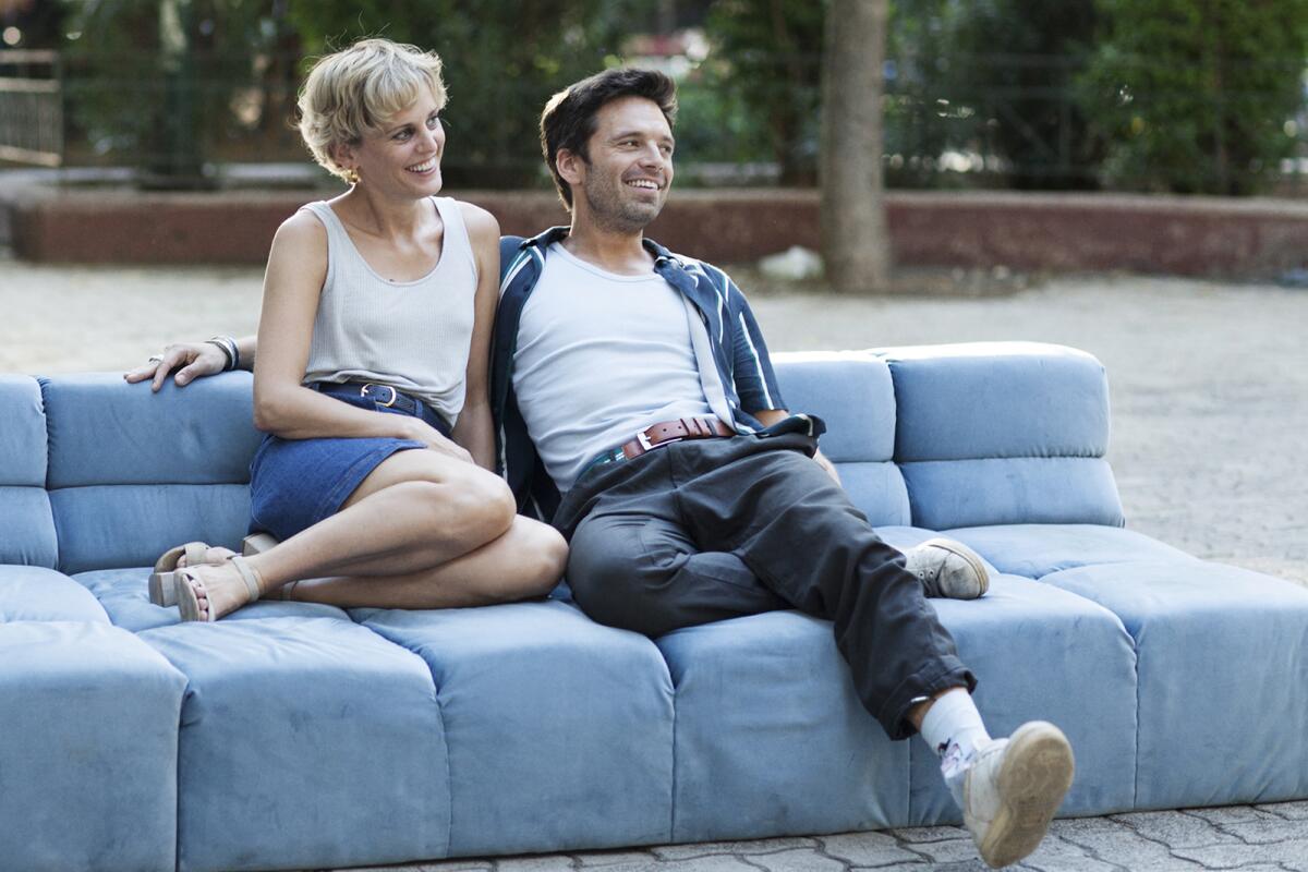 Denise Gough and Sebastian Stan lounge on a sofa in the movie "Monday."
