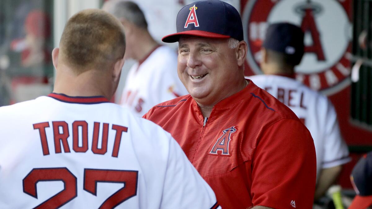 Angels Manager Mike Scioscia talks to star outfielder Mike Trout in the dugout before a game against the White Sox on July 15.