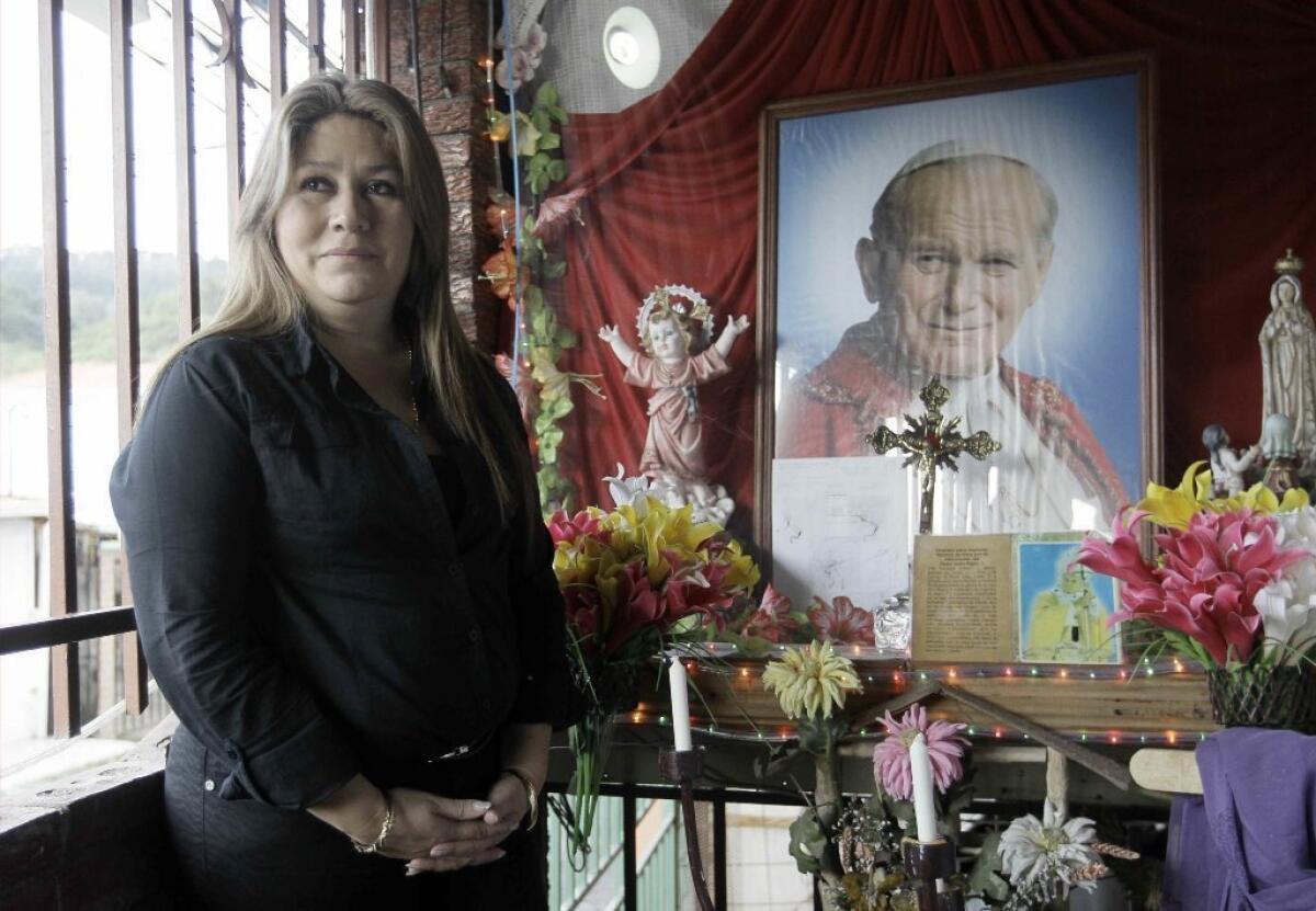 Floribeth Mora in front of a shrine to Pope John Paul II in Costa Rica. Mora was healed of a brain aneurysm, a cure that the Catholic Church is citing to advance John Paul II's path to sainthood.