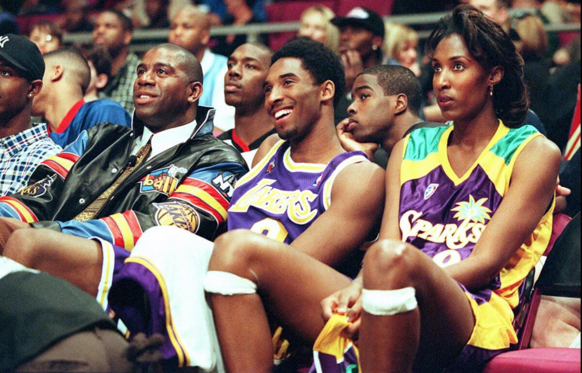 Lakers star Kobe Bryant, center, sits between Magic Johnson, left, and Sparks star Lisa Leslie at an event during the 1998 NBA All-Star Weekend in New York.