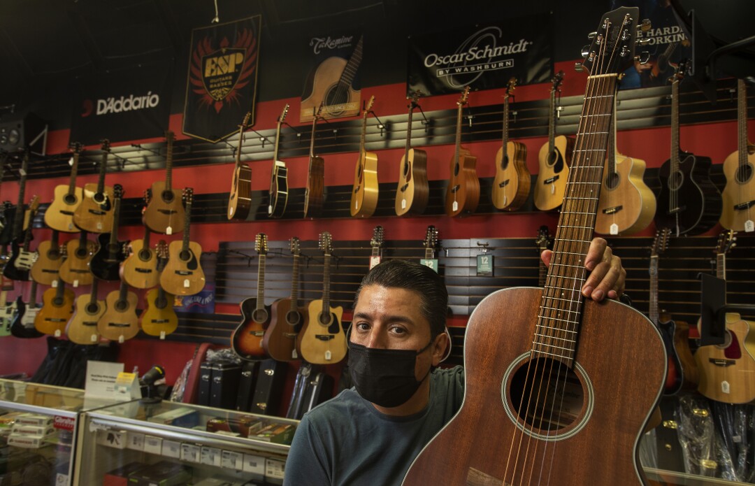  Jose Antonio Olvera, 49, owner of Olvera Music, holds a guitar  