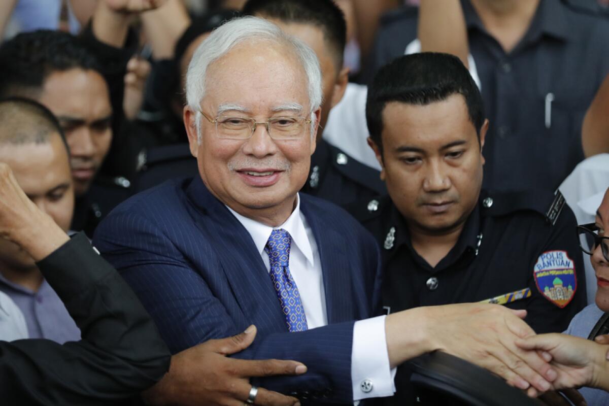 Former Malaysian Prime Minister Najib Razak is escorted from a courthouse in Kuala Lumpur last November.