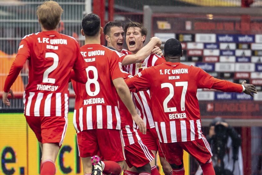 Berlin's Kevin Behrens, second from right, celebrates with teammates after scoring his side's second goal during the German Bundesliga soccer match between Union Berlin and Stuttgart, at the Alte Forsterei Stadium, in Berlin, Saturday, April 1, 2023. (Andreas Gora/dpa via AP)