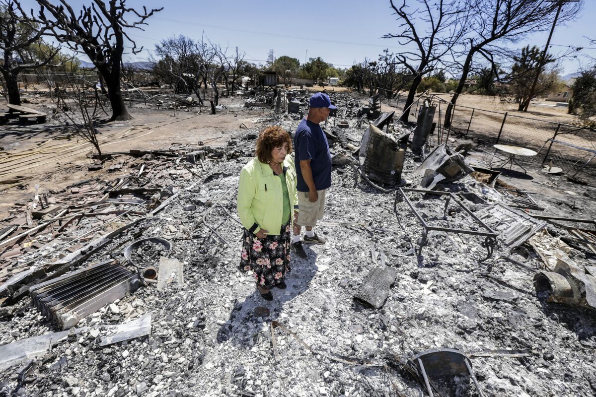 Miguel and Mabel Ramos, both 73, survey the devastation of the Blue Cut fire after it swept through their Oak Hills residence.