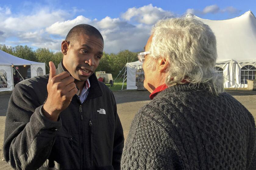 Congressional candidate Antonio Delgado talks with a potential voter while campaigning, Saturday, Oct. 13, 2013 in Schodack Landing, N.Y. Delgado is challenging Republican U.S. Rep. John Faso for the District 19 seat. (AP Photo/Mary Esch)