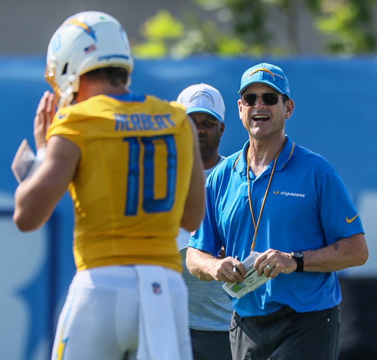 Chargers coach Jim Harbaugh talks with quarterback Justin Herbert during training camp 