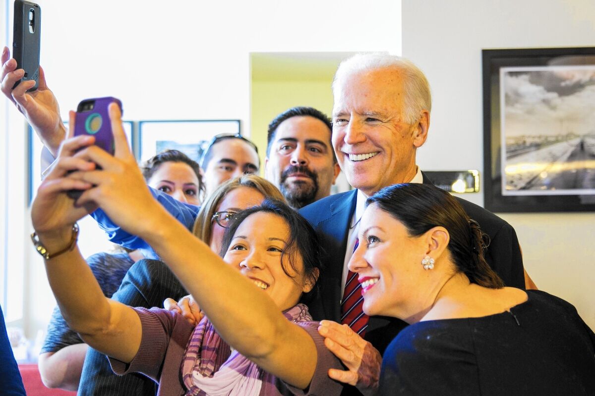 Vice President Joe Biden poses for photos with patrons at Homegirl Cafe near Chinatown while visiting L.A. to promote healthcare and the Obama administration's new community college proposal.
