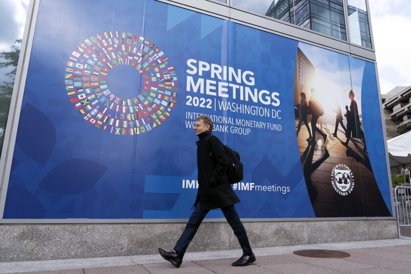 A person walks outside of the International Monetary Fund (IMF) building, during the first day of the World Bank/IMF Spring meetings in Washington, Tuesday, April 19, 2022. (AP Photo/Jose Luis Magana)