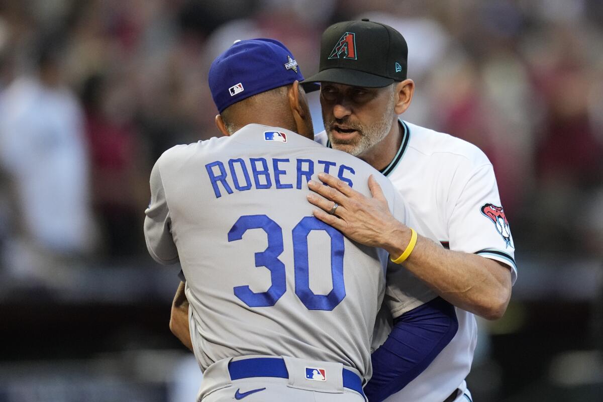 Dodgers manager Dave Roberts hugs Arizona Diamondbacks manager Torey Lovullo.