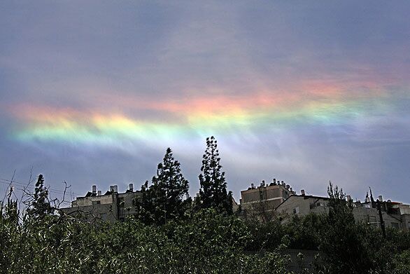 Clouds refract light over the western outskirts of Jerusalem. The colors appeared for about 20 minutes at noon before fading away.