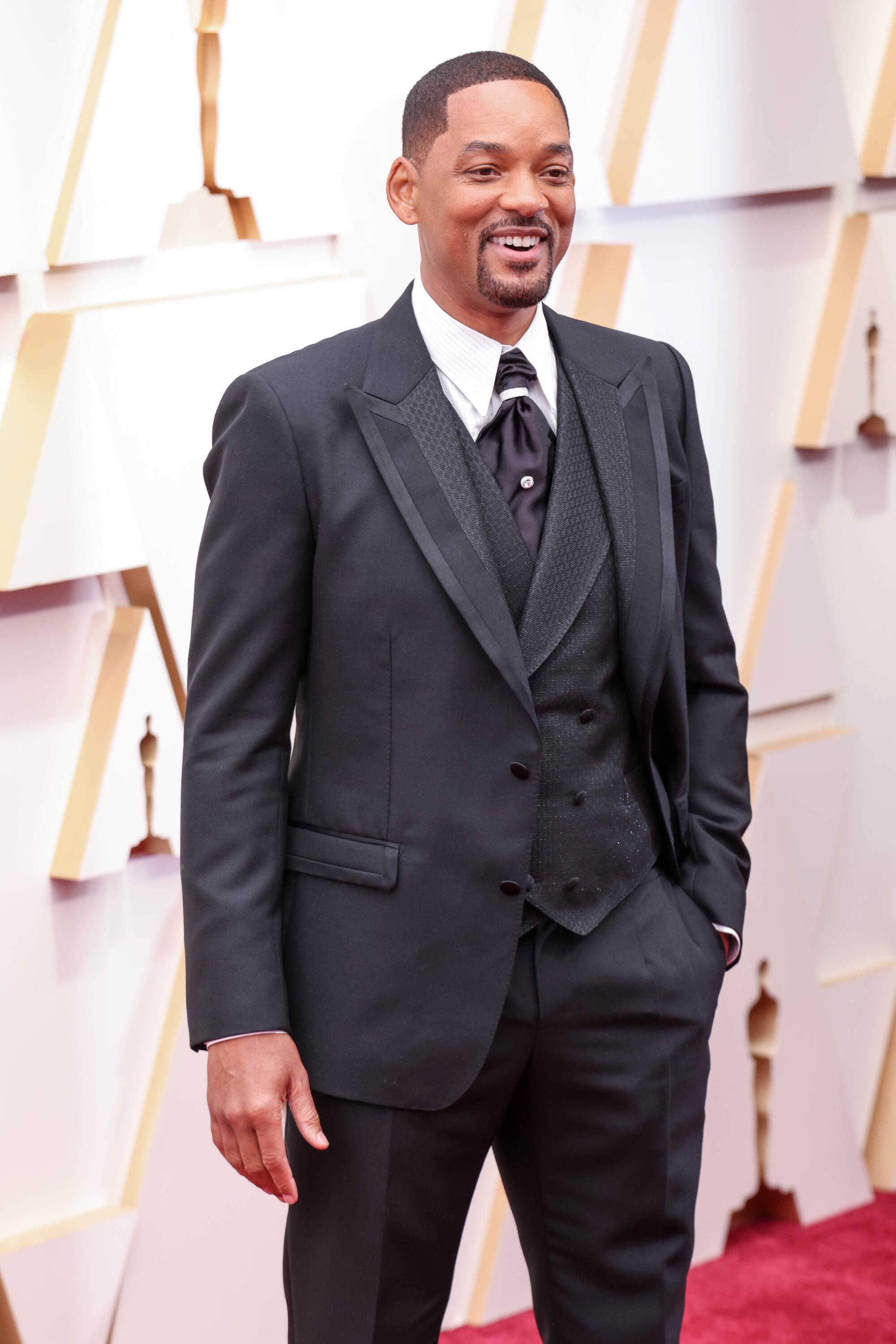 A man in a suit on the red carpet at the Academy Awards.