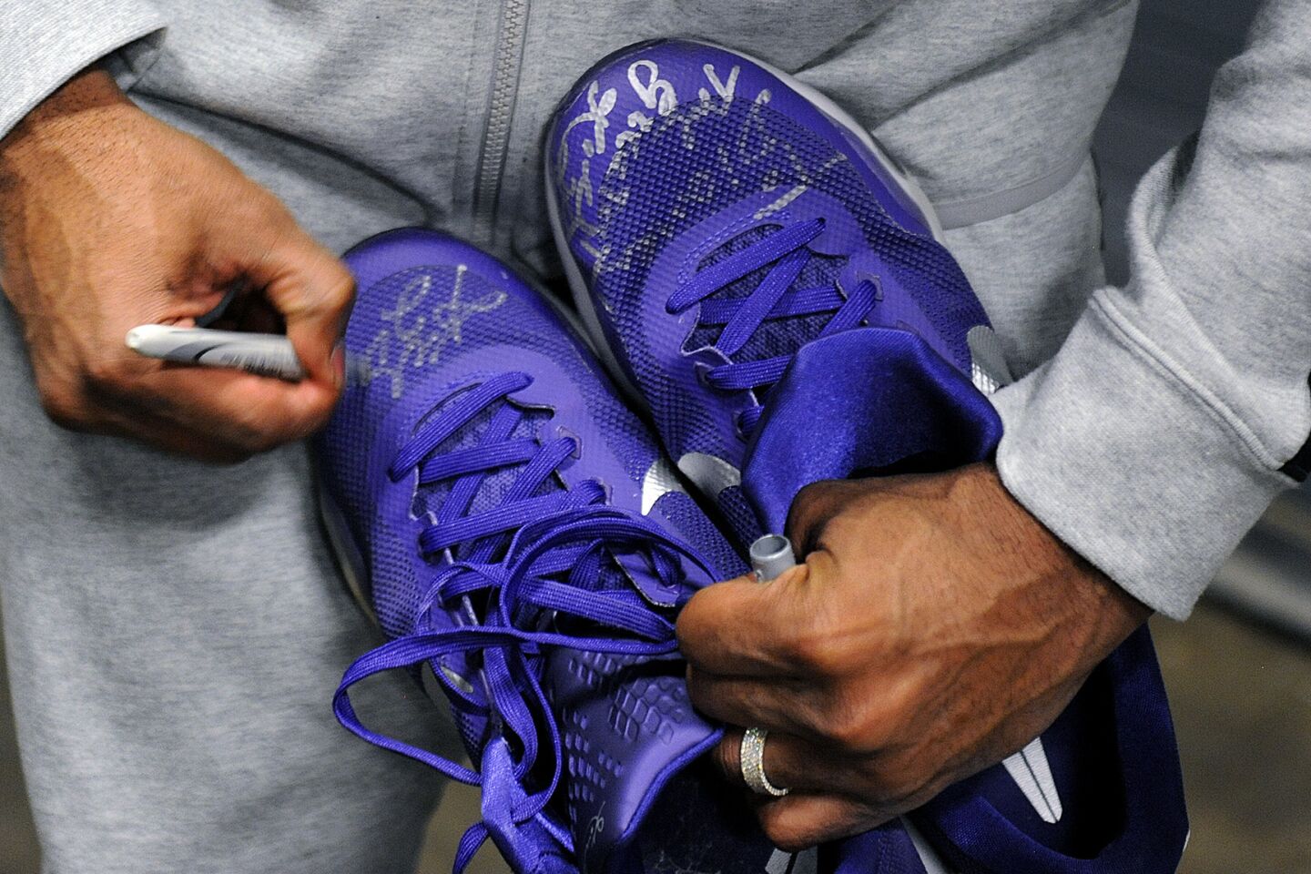 Kobe Bryant signs a pair of shoes for a fan after a game against the Suns in Phoenix on March 23.