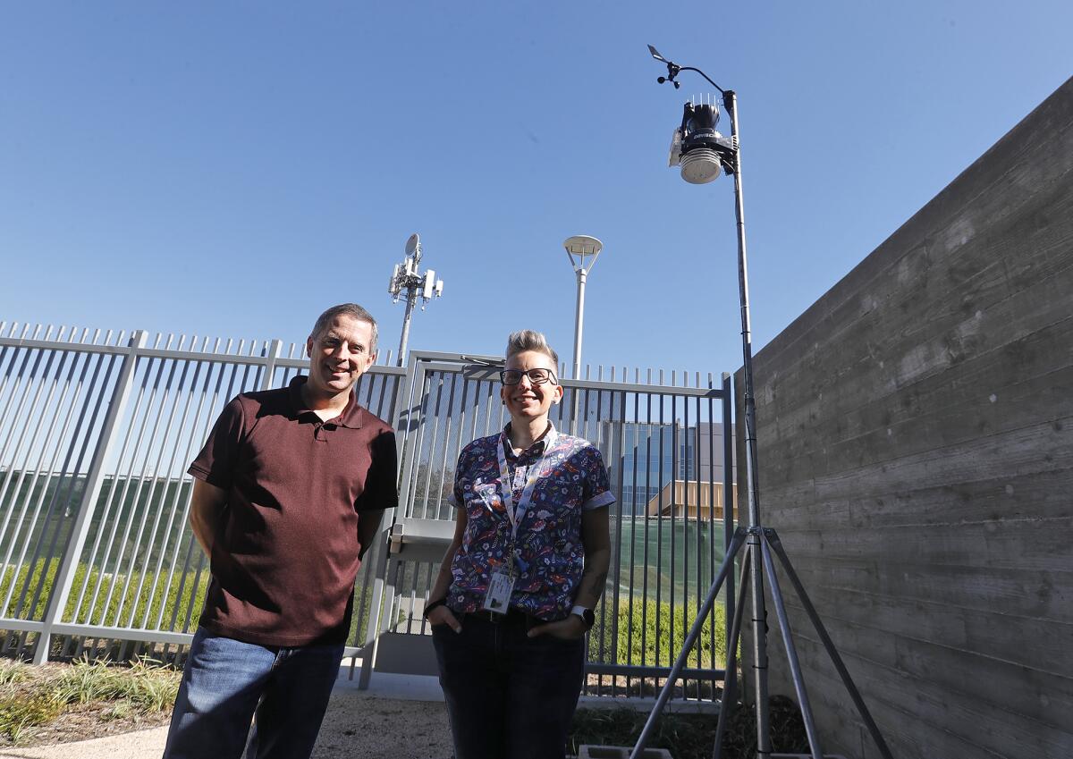 Geography professors Chris Quinn, left, and Jaime Speed stand next to a new weather station installed at OCC in July.