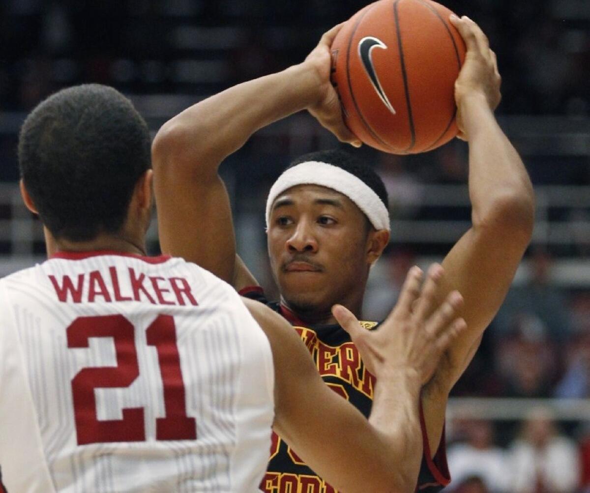 USC guard Elijah Stewart looks to pass as Stanford forward Cameron Walker (31) defends during the first half of a game on Feb. 25.