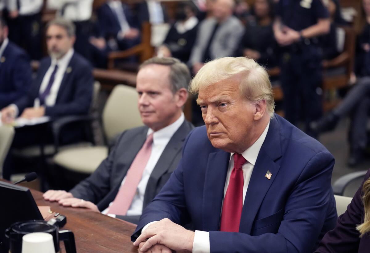 Donald Trump scowls as he sits in a courtroom