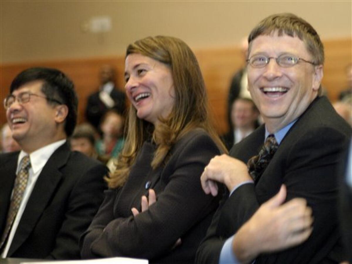 FILE - In this Sept. 12, 2003, file photo Washington Gov. Gary Locke, left, Bill and Melinda Gates, respectively right and center, react to comments by former New York Gov. Mario Cuomo during the grand opening of the William H. Gates Hall, the new home of the University of Washington School of Law, named after Bill Gates' father, in Seattle. (AP Photo/John Froschauer, File)