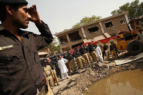 Officers in Lahore, Pakistan, survey the scene outside their precinct, called Rescue 51, where a car bomb was detonated. Thirty people were reported killed, and 250 injured.