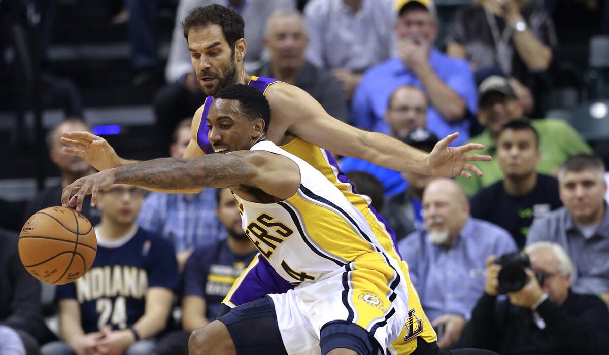 Indiana Pacers guard Jeff Teague fights to control the ball while defended by Lakers guard Jose Calderon during the first half Tuesday.