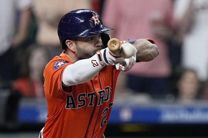 Houston Astros' Jose Altuve hits an RBI bunt single during the seventh inning of a baseball game against the Seattle Mariners Friday, May 3, 2024, in Houston. (AP Photo/Kevin M. Cox)