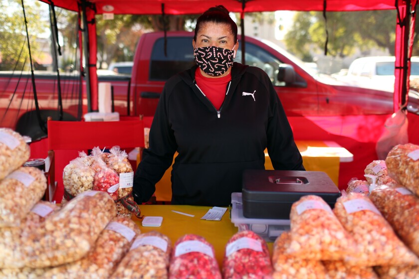 COVID-19 hit Latinos hard. Now officials must build trust
around vaccine in the community 4 Magda Navarro at her kettle korn stand at a farmers market