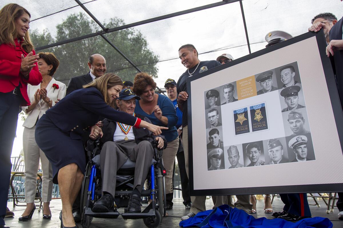 U.S. Congresswoman Loretta Sanchez shows Tibor Rubin a photo of himself as a young man during a Medal of Honor Korean War stamp dedication ceremony during the 2014 Veterans Day celebration at the Orange County Fairgrounds on Tuesday. Rubin, an Army corporal, received the Medal of Honor for his actions in the Korean War.