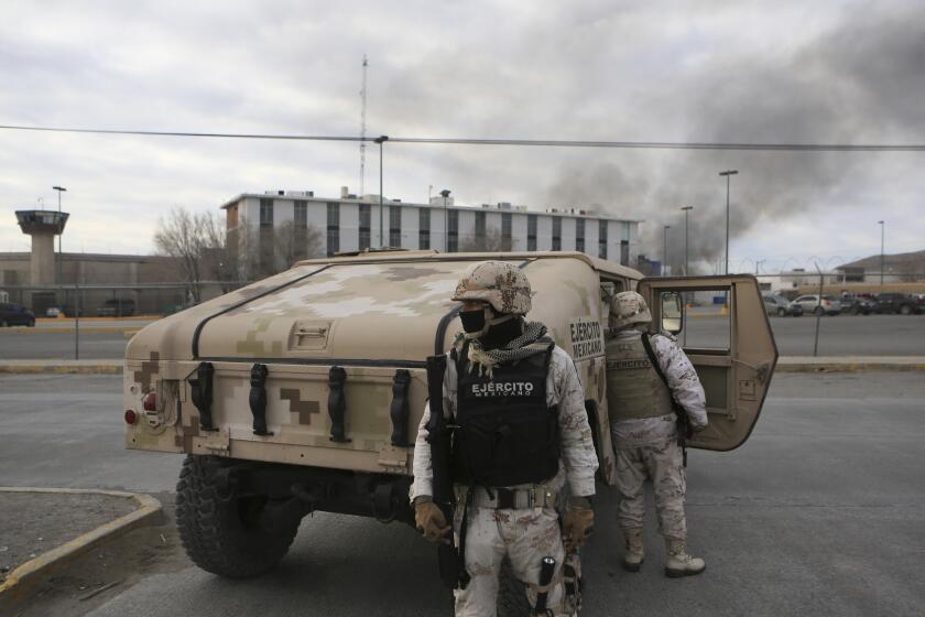 Mexican soldiers stand guard outside a state prison in Ciudad Juarez, Mexico, Sunday Jan 1, 2023. Mexican soldiers and state police regained control of a state prison in Ciudad Juarez across the border from El Paso, Texas after violence broke out early Sunday, according to state officials. (AP Photo/Christian Chavez)