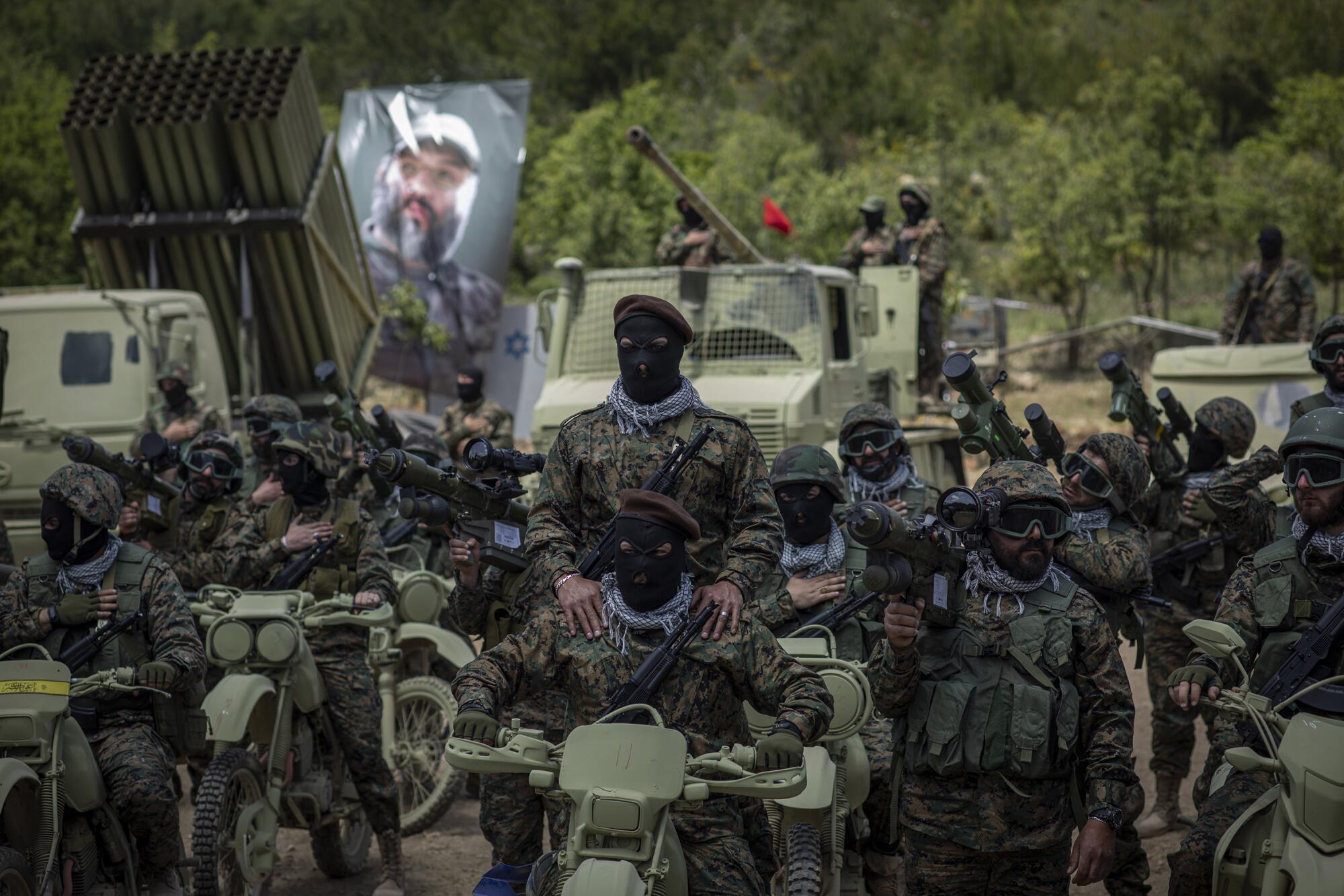 Hezbollah fighters hold a training exercise with weapons and vehicles.