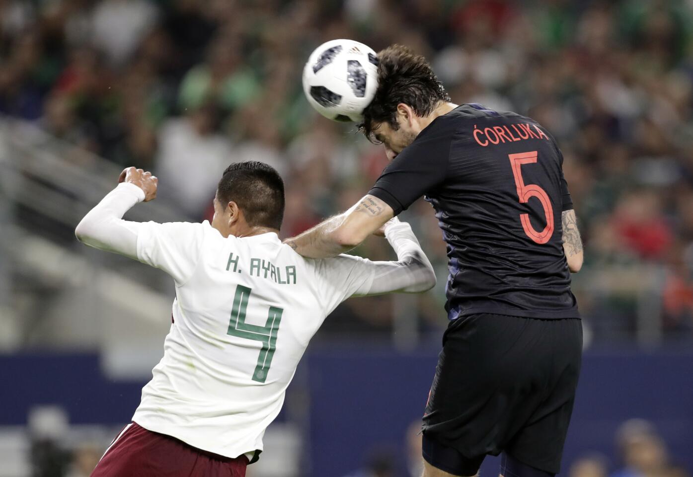 Mexico defender Hugo Ayala (4) defends as Croatia defender Vedran Corluka (5) heads to ball at the net off a corner kick in the first half of a friendly soccer match in Arlington, Texas, Tuesday, March 25, 2018. The shot by Corluka did not score. (AP Photo/Tony Gutierrez)