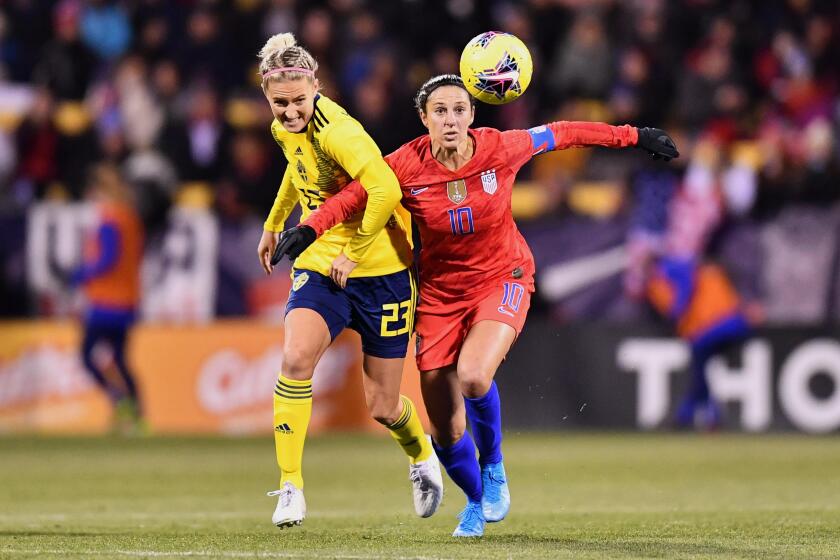 Carli Lloyd, right, battles Sweden’s Emma Kulberg during a match in November.