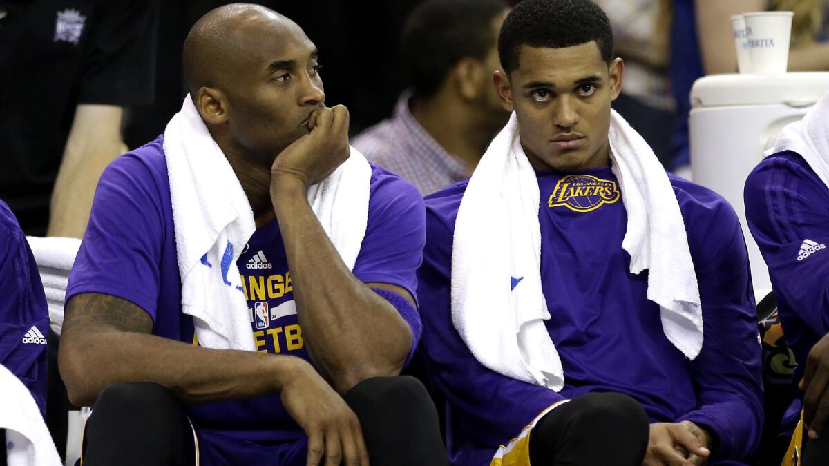 Lakers guards Kobe Bryant, left, and Jordan Clarkson rest on the bench during the second half of their game against the Kings on Friday night.