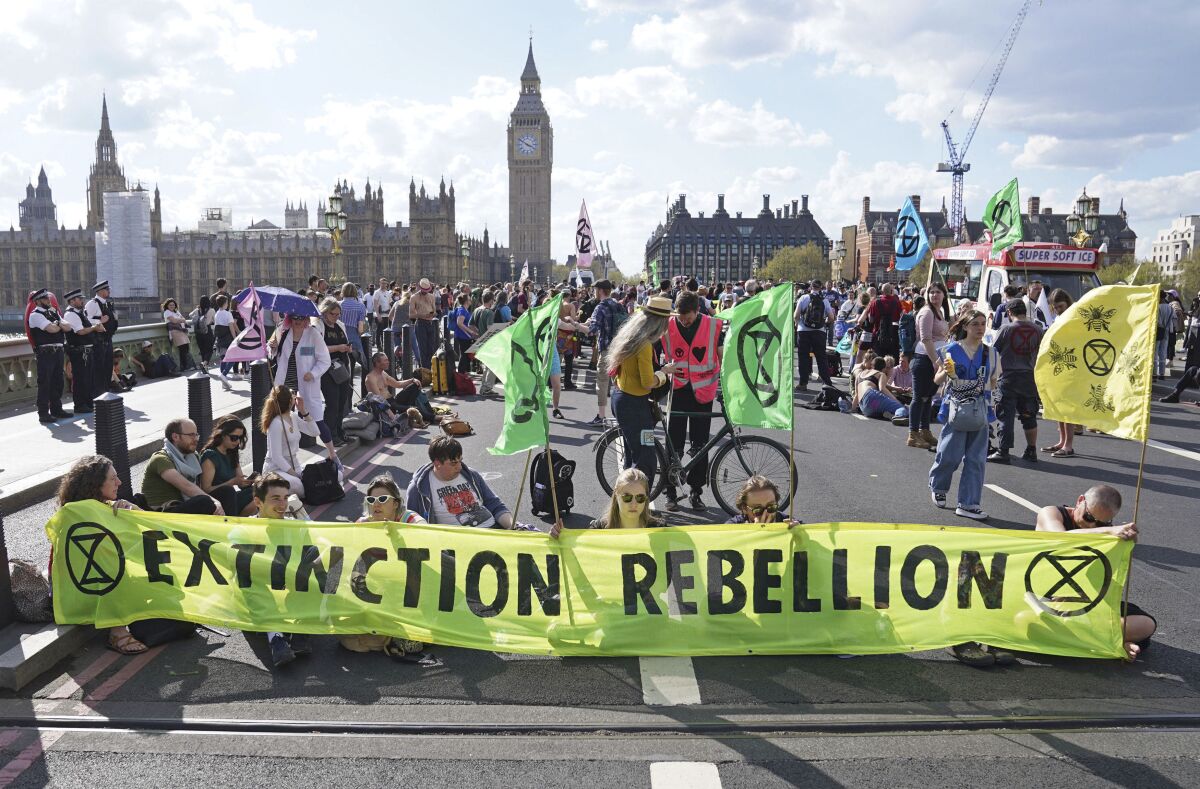 Demonstrators take part in an Extinction Rebellion protest on Westminster Bridge in London, Friday, April 15, 2022. Climate-change protesters have snarled traffic by blocking four London bridges. Cars and red double-decker buses backed up along roads as hundreds of Extinction Rebellion activists occupied London’s Waterloo, Blackfriars, Lambeth and Westminster bridges, calling for an end to new fossil fuel investments. (Stefan Rousseau/PA via AP)