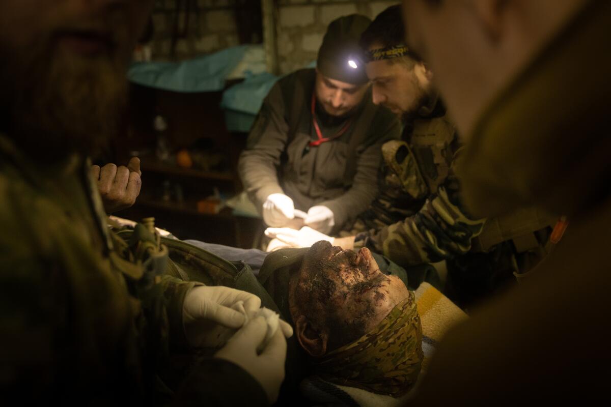 Military medics work on a member of the Ukrainian military in a frontline field hospital.