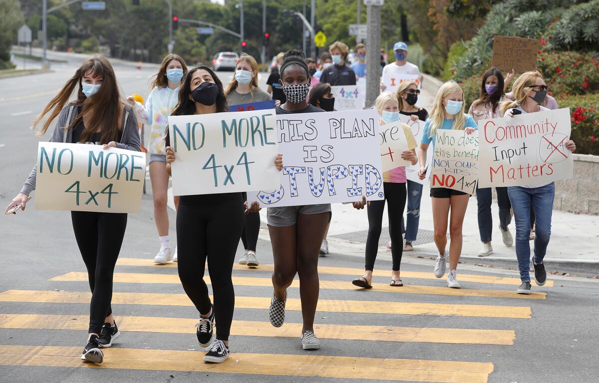 Students walk along Eastbluff Drive in front of Corona del Mar High School on Monday.